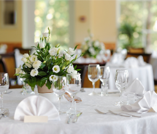 in Tisch mit weißen Tischdecken, der für eine Veranstaltung oder ein festliches Essen gedeckt ist